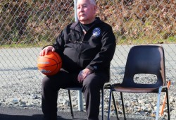 Alberni Indian Residential School survivor Charlie Thompson sits on the new court, where Peake Hall once stood. (Holly Stocking photo)