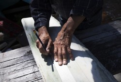 Joe Martin maps out where he will cut into the lower jaw bone of a grey whale outside his workshop in Tofino.