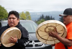 Several stops were made on the way to the Harbour Quay, including in front of the Thunderbird Building, where the group drummed and sang. (Alexandra Mehl photo)