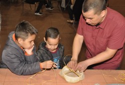 Trevor Little, right, helps Evan (left) and Brett Lucas build a drum for their sister, Victoria.