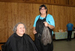 Myra Mack holds Irine Robinson's hair after cutting it during the Tour de Rock fundraiser. 