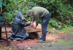 Gary and Joe Martin measure the bow on the dugout canoe.