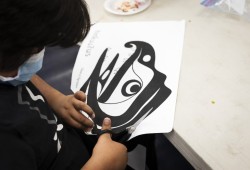 Carder Moulton, 9, cuts out the outline of a design that will adorn the Wickaninnish Community School's regalia, in Tofino, on November 22, 2021.