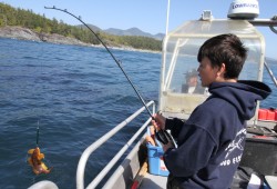 Brayden Tom fishes from a boat driven by his grandfather Carl Edgar.