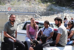 Clean Energy BC’s Cole Sayers, left, and Hesquiaht chief Mariah Charleson, centre, hitch a ride in the back of the truck for the site tour.