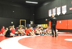 Coach Travis Cross speaks to young wrestlers on the ADSS team.