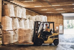 A Cermaq employee drives a forklift to move feed for the company's fish farms. (Cermaq Canada photo)