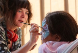 Charli Jaenta paints the face of five-year-old Adi Charleson-Raiwako at the Port Alberni Friendship Center. 