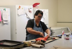 Gina Pearson demonstrates how to fillet salmon at E.J. Dunn school. (Alexandra Mehl photo) 