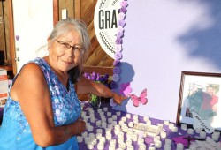 Dee points the names of loved ones Tommy and Ruth during an awareness event for families affected by drug overdoses that was held Port Alberni’s Harbour Quay in August 2022. (Denise Titian photo)