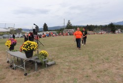 Eighth Avenue Learning Centre (EALC) Principal David Maher walks across a field lined with students on Sept. 25. (Denise Titian photo)