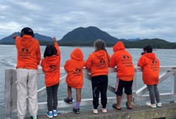 Tla-o-qui-aht children wait for residential school warriors as they paddle from Kakawis to Tofino for Orange Shirt Day. 