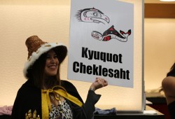 Tanesha Clarke holds a sign for Ka:'yu:'k't'h'/Che:k'tles7et'h' graduates to come together to be recognized.