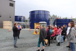 Eileen Floody, Tofino resident and long-time advocate of the sewage treatment plant, carries a poop emoji pillow on the Aug. 22 site tour led by Simon Kirkland.