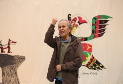 Mowachaht/Muchalaht Tyee Ha'wilth Mike Maquinna addresses the crowd as his muschim start singing.