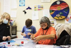 First Nations support worker Grace George helps Grade 3-4 students with their art projects at the Wickaninnish Community School, in Tofino, on November 22, 2021. (Melissa Renwick photo)
