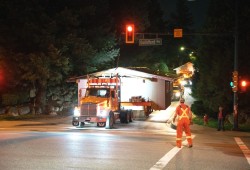 Port Moody home being relocated and moved through town by truck. 