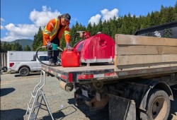 Mary Mercedes Lucas of Ditidaht Public Works fills a tank with fuel for the community at Nitinaht Lake, which has relied on generators since the Mount Underwood wildfire cut off power on Aug. 11. (Judi Thomas photo)