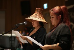 Norma Johnson (left) and Selena Lord read the Salmon Parks Declaration in Nuu-chah-nulth at the House of Unity on Dec. 3, as the community of Tsaxana and supporters celebrated the growing project. 