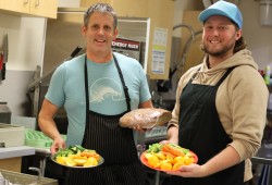 Chef Ron Weeks, left, and chef Solomon Wiebe hold up healthy snack trays and baked bread for Tofino’s Wickaninnish Community School children.