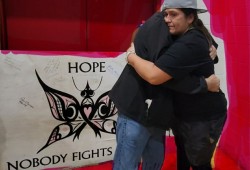 Lambert embraces Shae Doiron during a ball hockey tournament she has hosted annually to generate funds for cancer patients.