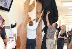 Principal Dave Maher and carver Gord Dick unveil a sculpture at the Eighth Avenue Learning Centre on May 26.