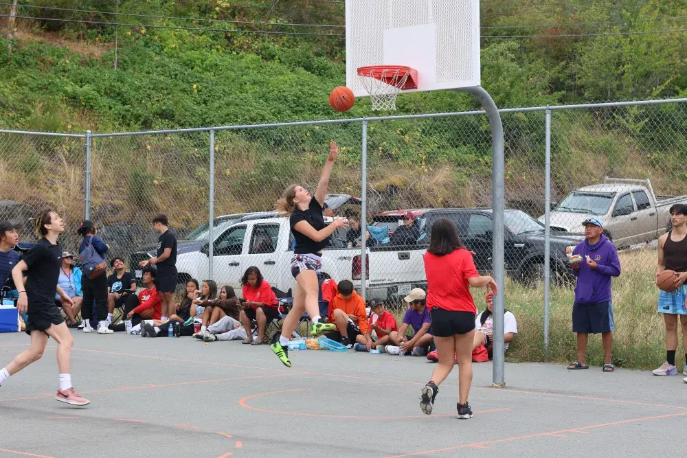 Wiinuk Martin takes a jump shot as her dad Dwayne looks on.