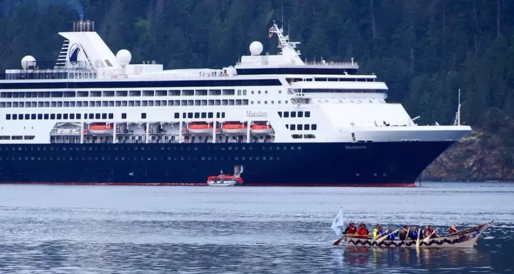 Tseshaht family paddlers greet Holland America’s cruise ship Maasdam after it dropped anchor in the Alberni harbour in 2019. (Mike Youds photo)