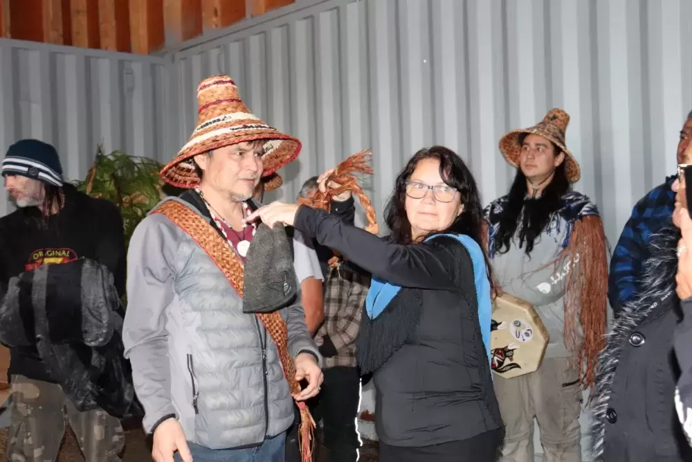 Makah carver Micah McCarty receives a gift from Sarah Wright Cardinal before the canoe launching. (Denise Titian photo)