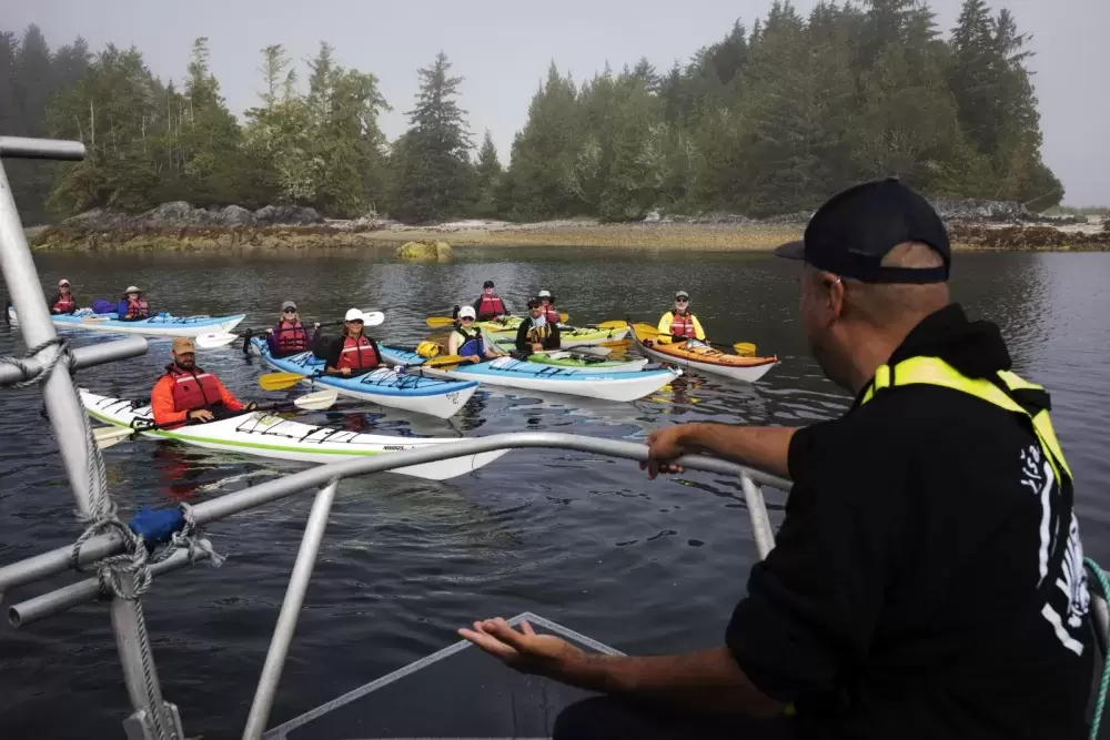 Tseshaht Beach Keeper Hank Gus asks a group of kayakers about their plans while in the Broken Groups Islands.