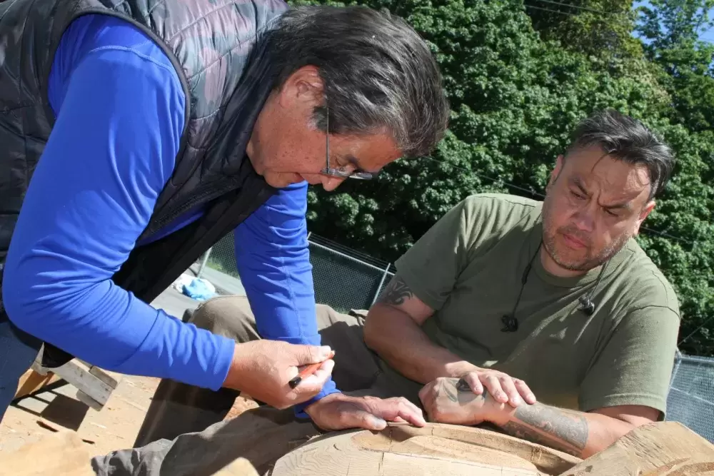 Tim Paul and Moy Sutherland Jr. rework a totem pole at Port Alberni's waterfront.