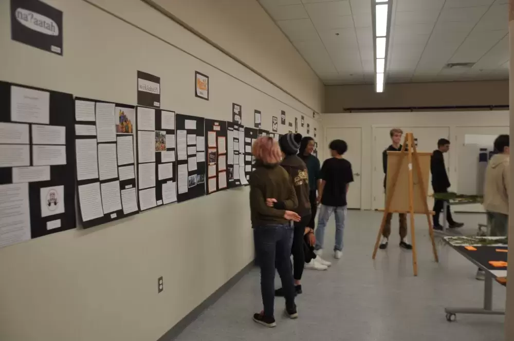 Ucluelet Secondary School's Grade 10 English class, the authors of the poetry collection, circulate the exhibit viewing student projects in the multi-disciplinary display. (Alexandra Mehl photos)