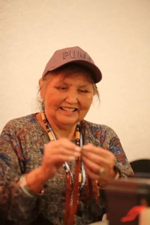 Alice George weaves cedar to make a rose.