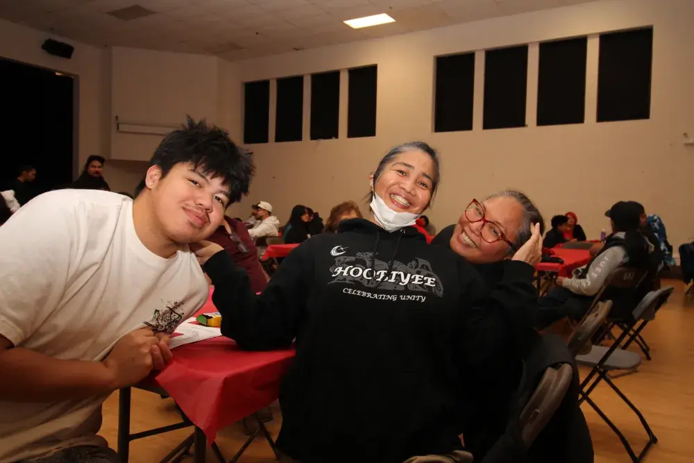 Huu-ay-aht's Keona Charles sits with Deb Cook and Sherri Cook.