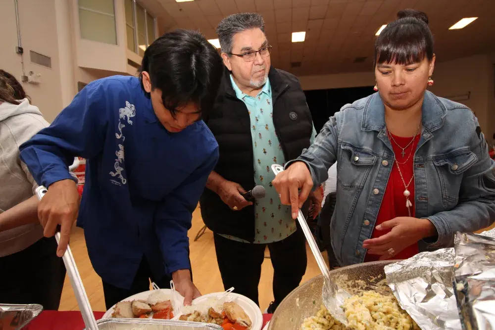 NTC Vice-President Les Doiron works the microphone as people scoop up meals to serve to elders.