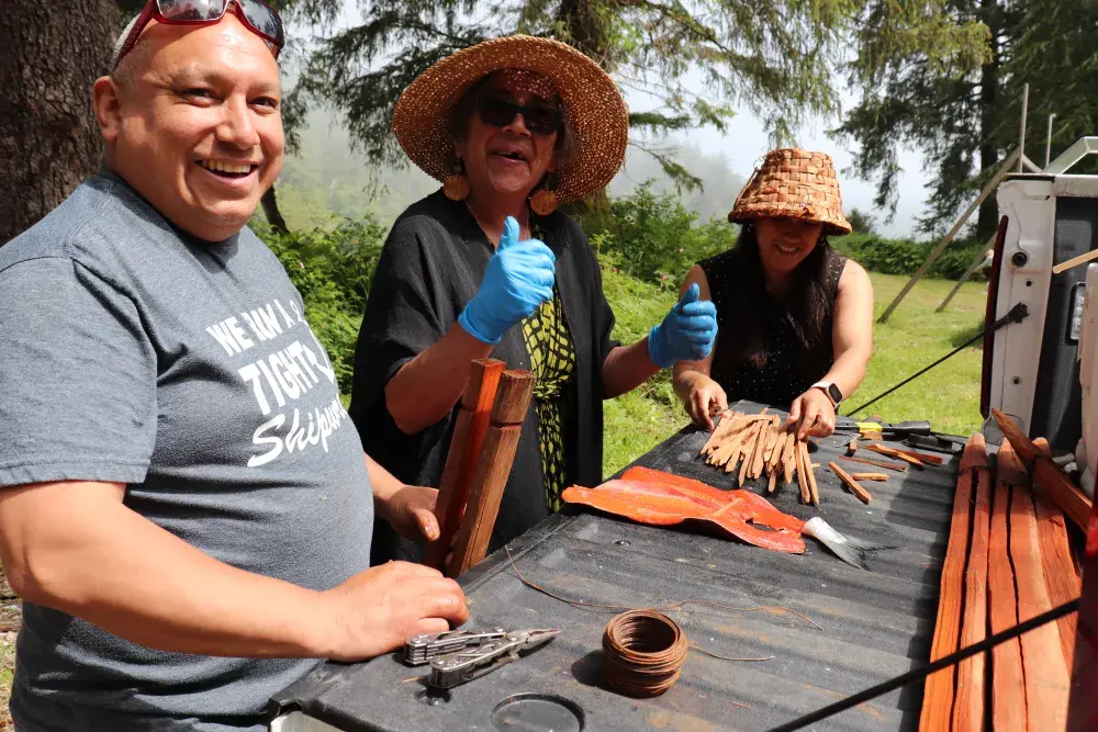 Stephen Smith, Charlene Nookemus and Mel Edwards put salmon on cedar sticks for a traditional barbecue.