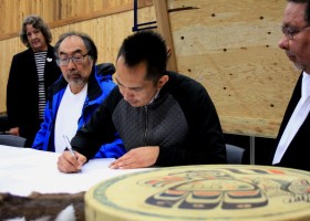 Huu-ay-aht Tyee Ha'wilth Tliishin signs the transfer documents