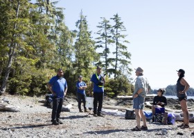 (From left to right) Shane Sieber, Memphis Dick and Hank Gus greet a group of kayakers on Gibraltar Island, in the Broken Group Islands, in Barkley Sound, on July 26, 2021.